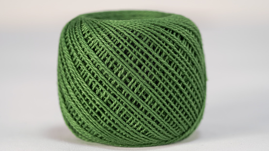 Green skein of thread on a white background. Close-up. Yarn ball for knitting and crochet.