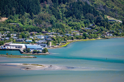 Enjoy the panoramic view of Havelock city in New Zealand, with a tranquil lake in the foreground. Explore this picturesque urban landscape.