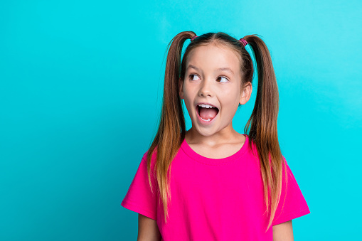 Photo of overjoyed cheeful adorable lovely girl dressed pink trendy clothes looking empty space news isolated on cyan color background.