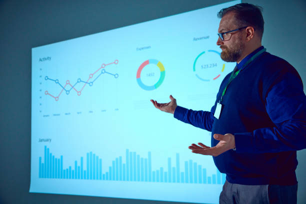 istock Entrepreneur gesturing while presenting his new ideas on meeting in conference hall standing near screen with charts. 2065766634