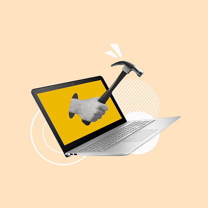 Creative collage of laptop and hand holding hammer. Modern design.  Copy space.