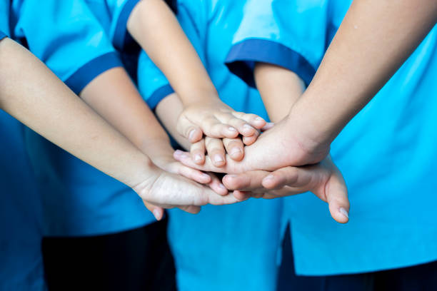 Asian children join hands, symbolizing their unity and support. A team of people formed for productive and integrated work.
