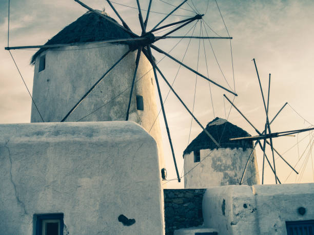The iconic silhouette of Santorini's windmills stands against the dusky sky, a testament to the island's enduring charm.