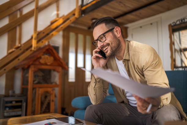 istock one adult man sit at home make a call while hold paper documents 2065863024