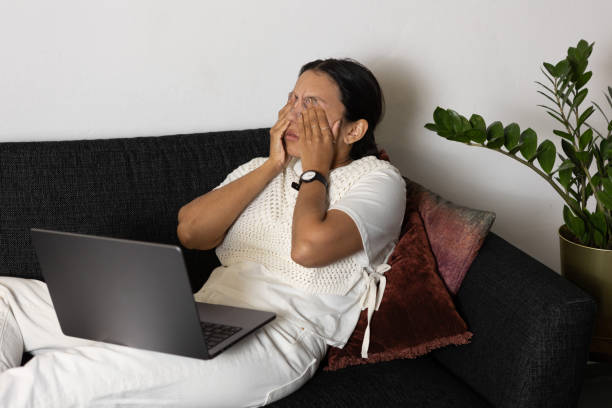 istock Tired woman using laptop and working from home sitting on couch 2065874179