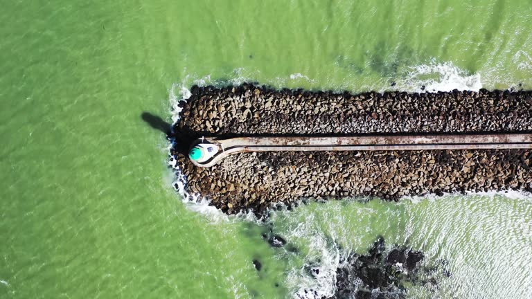 A beautiful seascape, a view of a lighthouse on the ocean, shot from a drone in 4K.