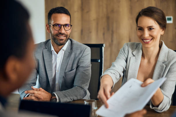 istock Business people interviewing with a client, giving him a contract to sign. 2065938844