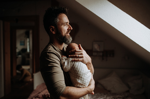 Father holding his newborn baby. Unconditional paternal love and Father's Day concept.