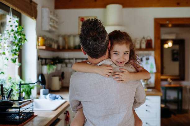 istock Daughter hugging father lovingly, looking at camera, smiling with gap-toothed grin. Unconditional paternal love, Father's Day concept. 2065954001