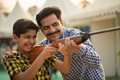 Father and son shooting gun at fair