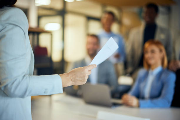 istock Focus on the female hand holding a document while talking to her employees. 2065959701