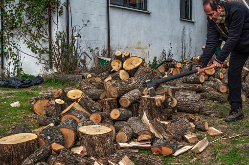 Simple Village Life: Man in Garden Splitting Logs with Axe