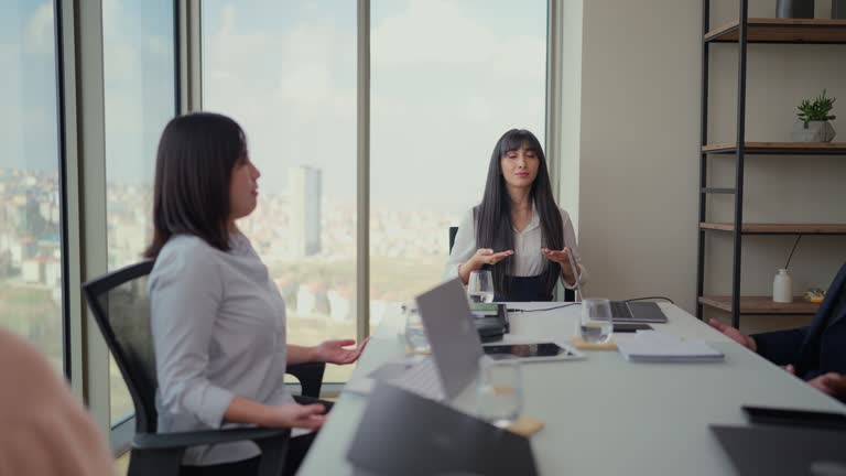 Business people doing breathing exercise and meditating at business desk in modern office