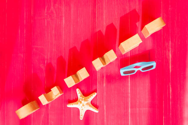 Composition with diagonal letters forming the word summer with the shadow and with starfish and sunglasses on a magenta or fuchsia background. Summer vacation concept.