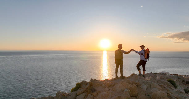 istock Mature couple ascend rock ridge crest 2066152479