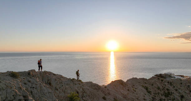 istock Mature couple ascend rock ridge crest 2066153024