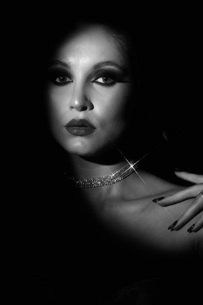 istock Woman portrait partly face covered with shadow and illuminated by studio light 2066162422