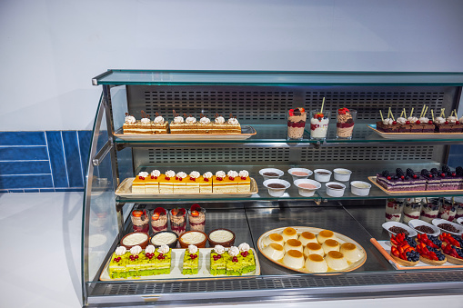 Close-up of shelves in restaurant with various types of sweet pastries.