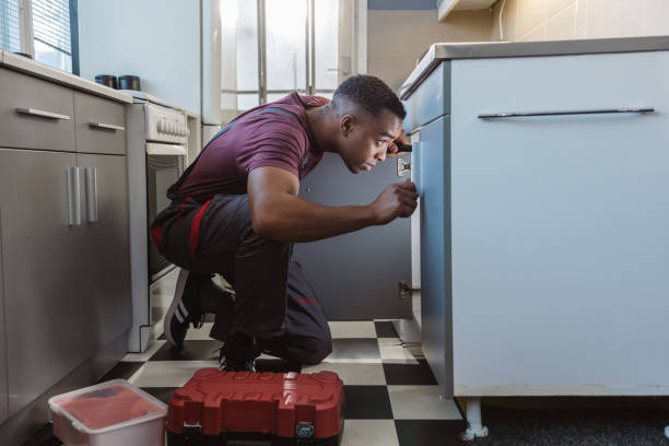 istock African American plumber repairs a broken water pipe under the sink 2066191330