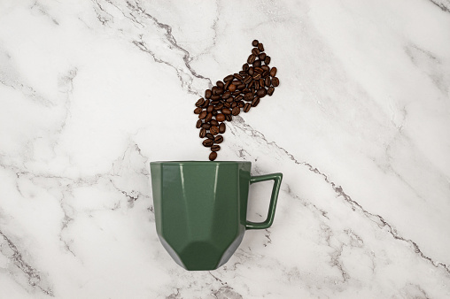 Top view of coffee cup on white marble background. Coffee beans and green cup flat lay. Copy space.