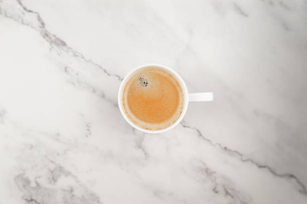 istock Top view of coffee cup on white marble background. 2066199823