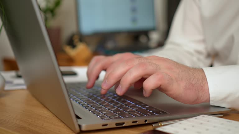 Man opens notebook and started typing on keyboard close up, nervous person at office desk, solving business problems