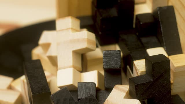 Close up piece of wooden block puzzle. Logical task. Slow motion. Concept of complex and smart logical thinking