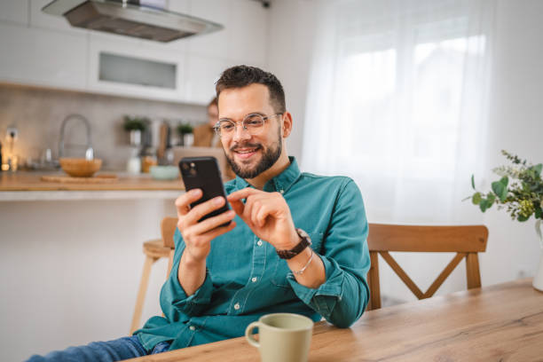 istock man with eyeglasses stand at home use mobile phone sms texting 2066216136