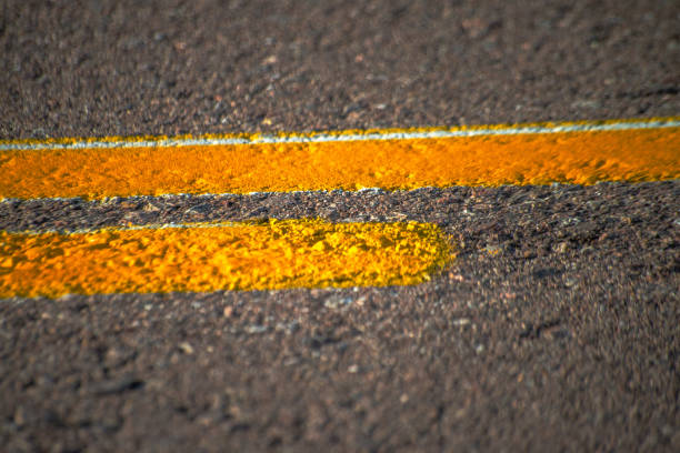 An asphalt road adorned with crisp white stripes, guiding urban travelers along a journey of smooth pathways and directional roads.