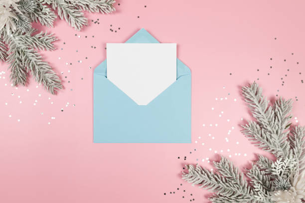 istock Christmas composition, light blue envelope, white card, fir tree branches, silver stars confetti on pink background. 2066238682