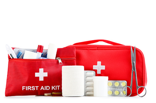 First aid kit with medical supplies isolated on white background