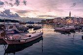 boats in the harbor in Rovinj in the evening with adriatic sea and sunset