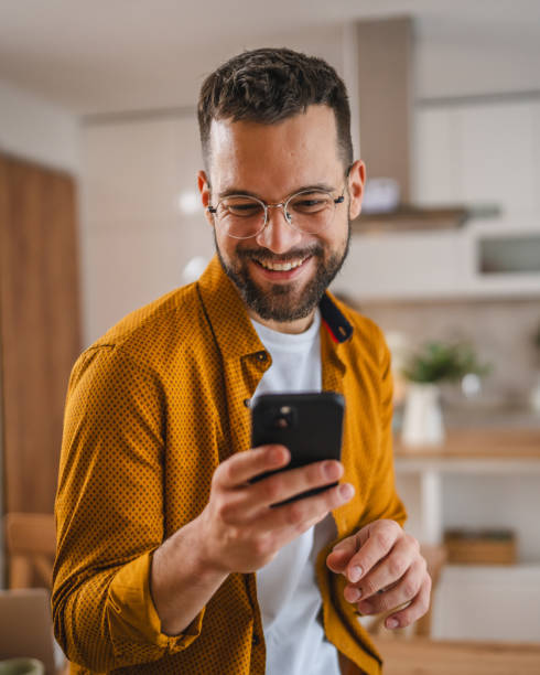 istock man with eyeglasses stand at home use mobile phone sms texting 2066282117