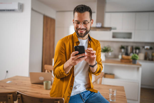 istock man with eyeglasses stand at home use mobile phone sms texting 2066294678