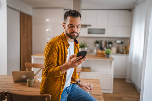 istock man with eyeglasses stand at home use mobile phone sms texting 2066294679