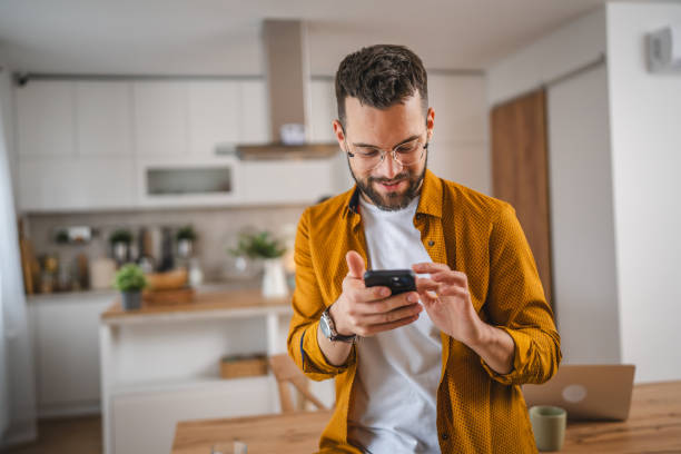 istock man with eyeglasses stand at home use mobile phone sms texting 2066313353
