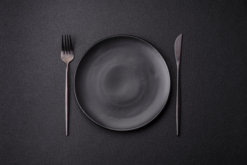 Cutlery fork, knife and spoon on a dark textured concrete background. Kitchen items and accessories