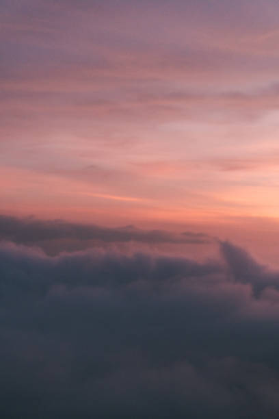 istock foggy sky during dusk - clouds and mist over mountains and beautiful orange sky 2066319156