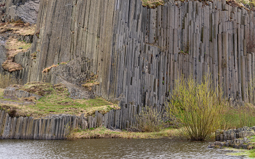 Tall and gray basalt columns. Basalt rock Panska Skala in Kamenice Senov, Czech Republic