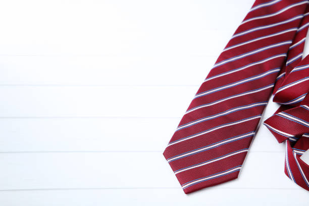 Striped necktie on white wooden table