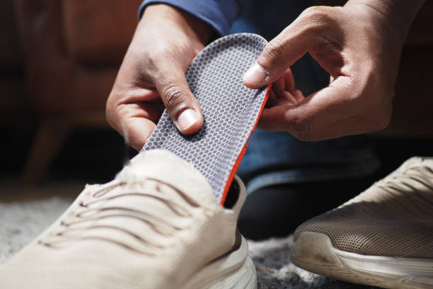 istock men hand putting Orthopedic insoles in shoes 2066367602
