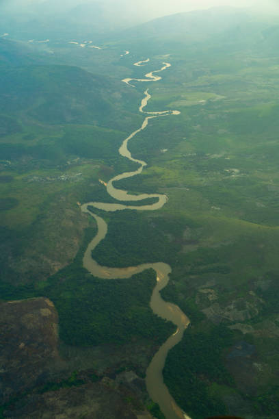 A scenic landscape with river flowing amidst mountains in the backdrop