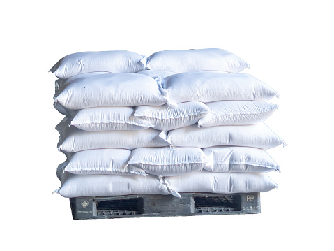 Stack of rice bags on plastic a pallet, isolated on white background.