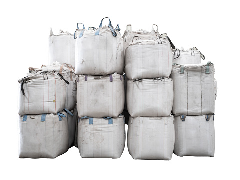 Stack of jumbo bags of raw material in warehouse, isolated on a transparent background. Agricultural product, paddy rice, rice, sugar, and starch in Jumbo bags for storage.