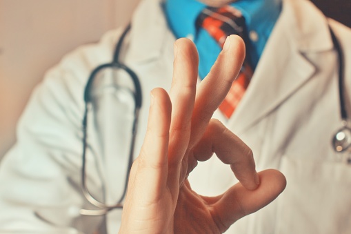 A male doctor making an upturned hand gesture. Studio isolated background, copyspace. Health, medical business banner