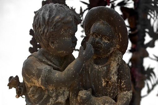 Sculpture of two chocolate children, one hugging the other, evoking feelings of friendship and affection.