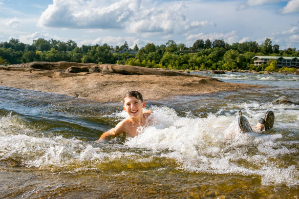 istock Teenage boy swimming in river rapids 2066432284
