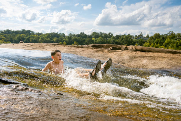 istock Teenage boy swimming in river rapids 2066443831