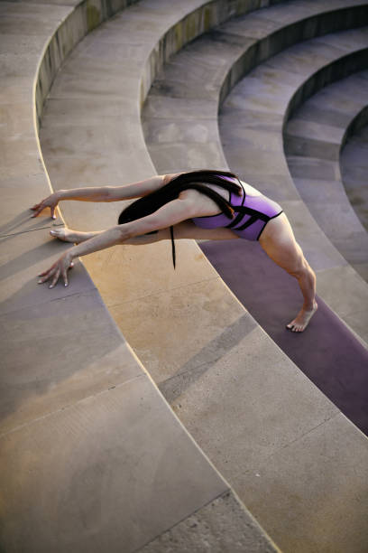 Yogini Stretching On Amphitheater Stairs
