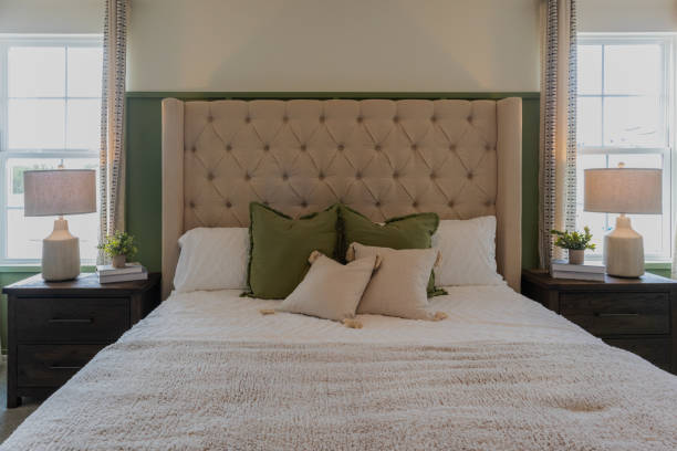 istock Queen size bed with tufted upholstered headboard with two night stand and lamps 2066484193